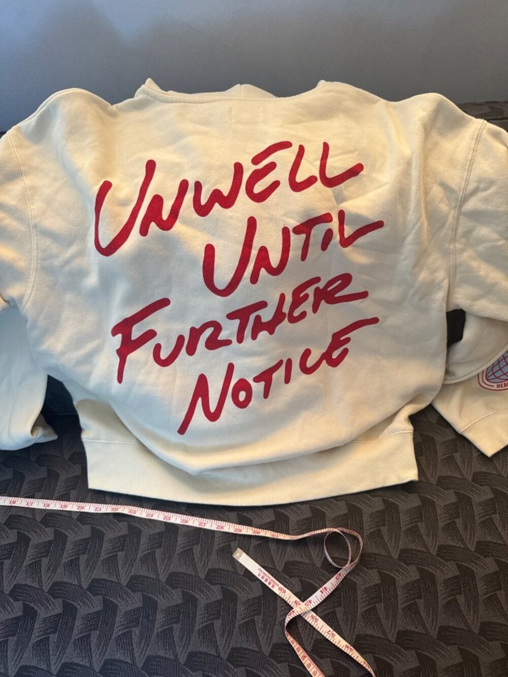 Unwell Until Further Notice Cream Hoodie With Red Graphics & Sleeve Details Kang